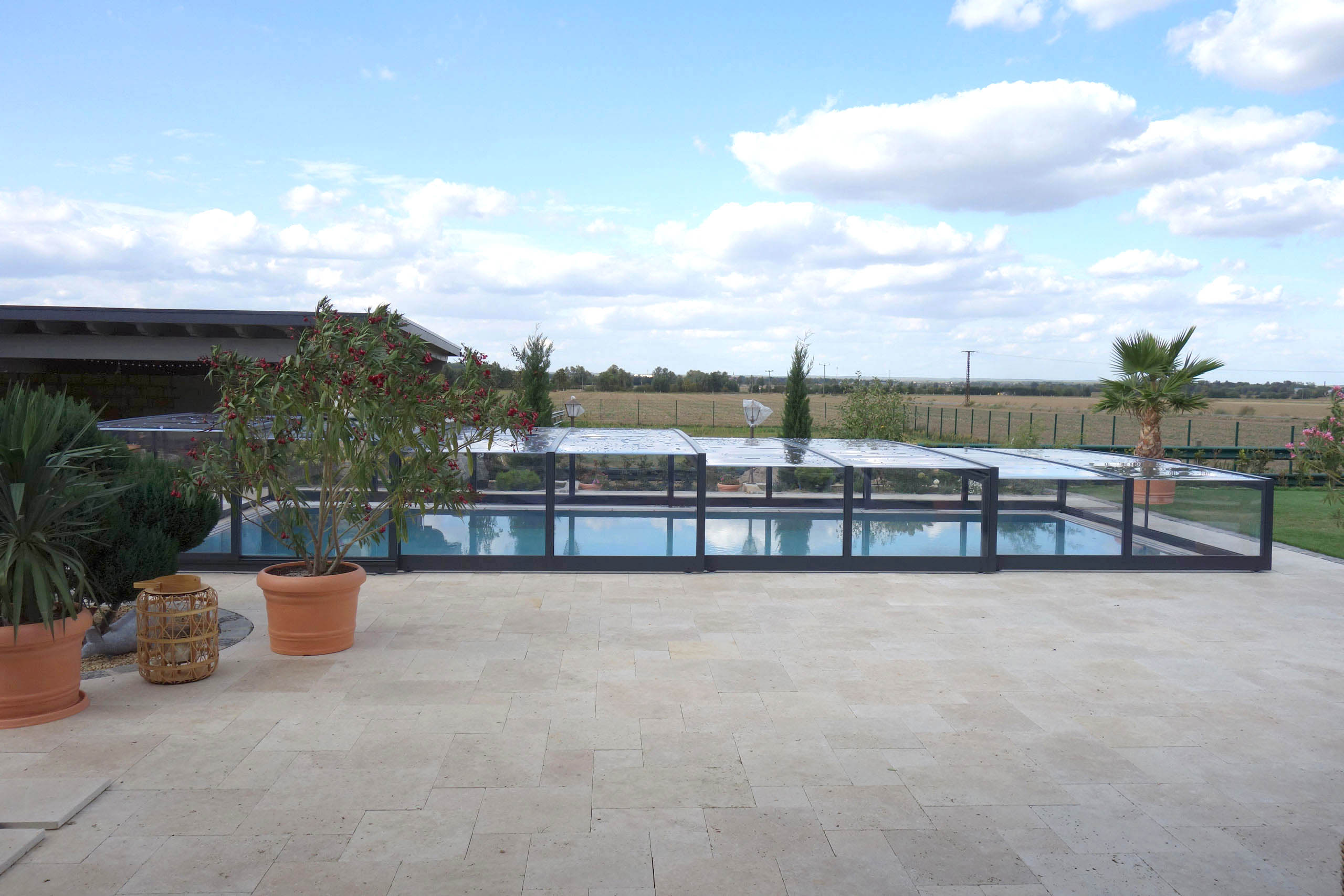 Poolüberdachung Prestige Plus in flacher Ausführung, seitlich geöffnet, mit Pool und Terrasse