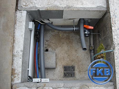 Installierte Pooltechnik mit Rohren, Kabeln und Absperrventil in einem Technikschacht