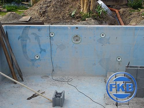 Detailansicht der Beckenwand mit alten Delfinmotiven und Einbauteilen vor der Sanierung