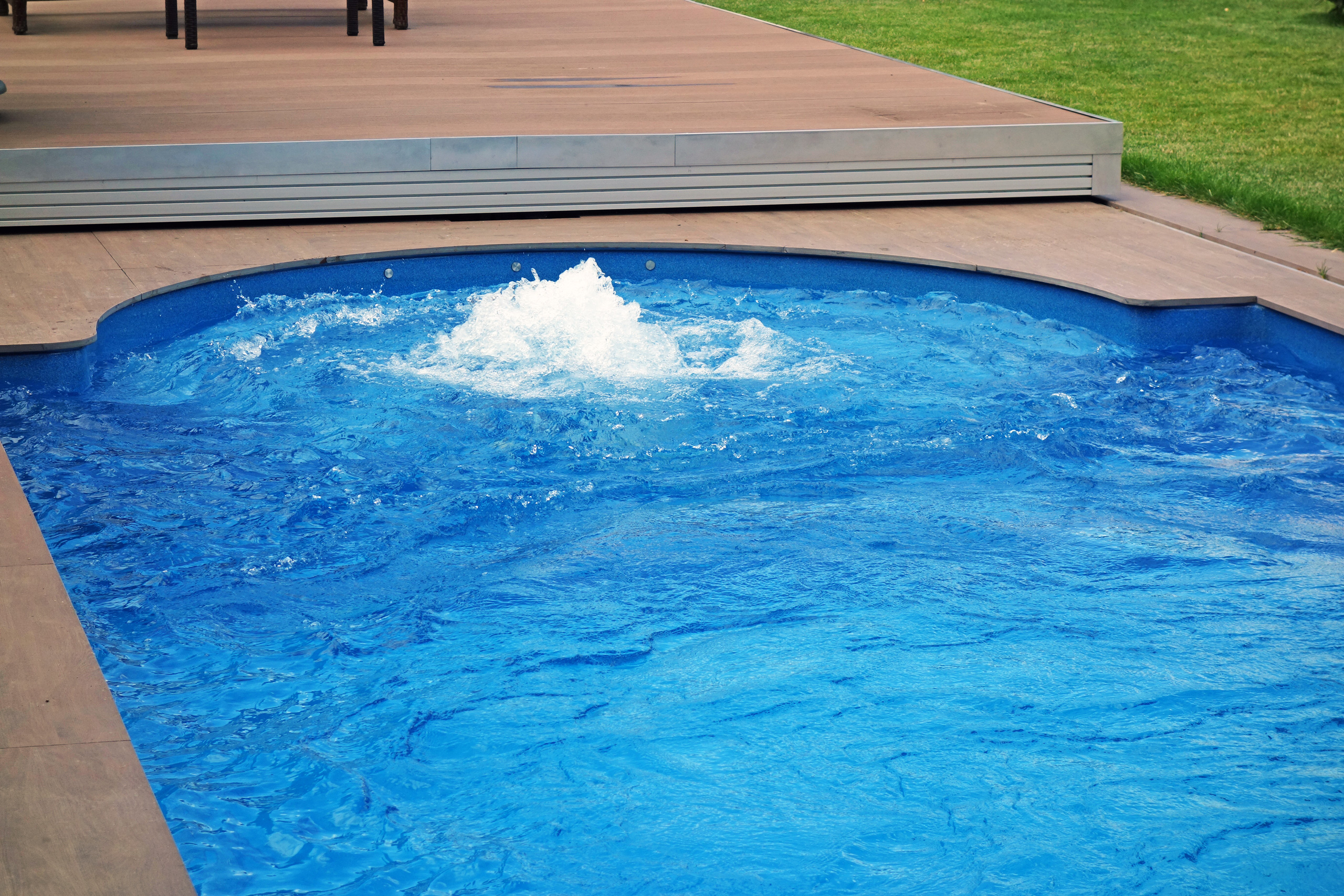 Sprudelndes Wasser im blauen Compass Pool Schwimmbecken Java 101 mit Terrassenabdeckung
